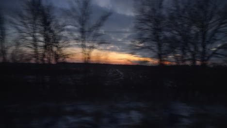 Orange-Sonnenuntergang-Himmel-Zugfahrt-Fenster-Pov-Vorbei-An-Silhouette-Von-Bäumen
