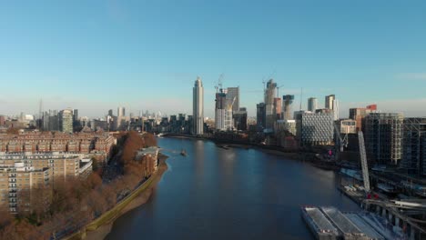 Dolly-forward-drone-shot-over-Thames-river-towards-The-Tower-Vauxhall-London