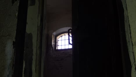 Der-Gefängniswärter-öffnet-Die-Tür-Des-Kerkers-Und-Zeigt-Ein-Fenster-Mit-Eisengittern