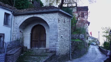 Antigua-Puerta-De-Casa-Con-Paredes-Arqueadas-De-Piedra-Y-Callejón-Pavimentado-En-Gjirokastra,-Albania