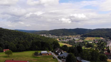 Aerial-side-flight,-captivating-view-of-Wilhemsfeld-town-on-sunny-and-cloudy-day,-Germany