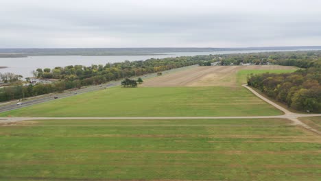 Schieben-Sie-Die-Luftaufnahme-über-Die-Grasbewachsenen-Felder-Der-Landschaft-Mit-Dem-Illinois-River-In-Der-Ferne