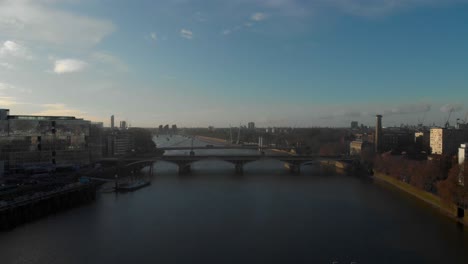 Dolly-back-falling-drone-shot-over-thames-river-Grosvenor-Chelsea-bridge-London
