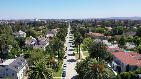 Drone-zooms-out-to-reveal-palm-tree-lined-streets-and-mansions-in-West-Hollywood,-California