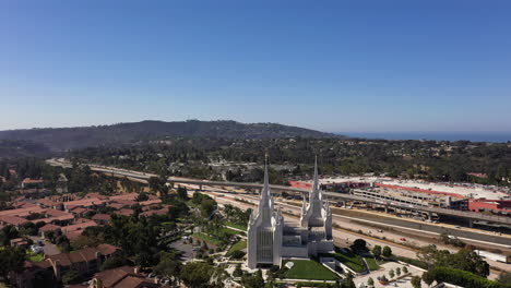 Aerial-View-Of-Latter-day-Saints-Mormon-Temple-And-Highway-5-In-San-Diego,-California---orbiting-drone-shot