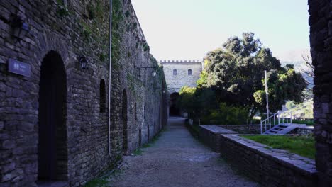 Inside-high-stone-walls-of-medieval-castle-of-Gjirokastra,-walking-on-quiet-alleys-at-morning