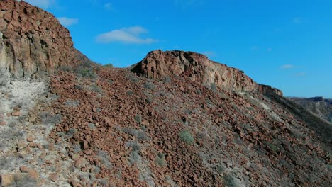 Luftaufnahme-Aufsteigender-Schuss,-Malerischer-Blick-Auf-Einen-Felsigen-Berg-In-La-Purisima-Baja-California-Sur,-Mexiko,-Blauer-Himmel-Im-Hintergrund