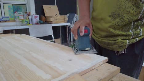 a-man-is-using-wood-sanding-machine-and-changing-hand-while-using-it
