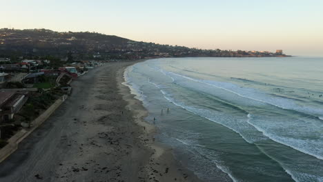 Luftaufnahme-Von-Touristen,-Die-Den-Strand-An-Der-Küstenlinie-Von-La-Jolla-In-San-Diego-Bei-Einem-Sonnenuntergang-Genießen---Absteigende-Drohne