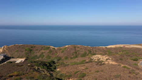 Drone-Flying-Towards-Torrey-Pines-Gliderport-On-Cliffs-Above-Black's-Beach-In-La-Jolla,-California---aerial