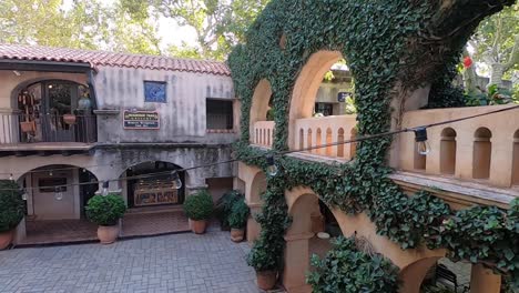 Tilt-up-from-a-cobblestoned-courtyard-to-Ivy-covered-arches,-Tlaquepaque,-Sedona,-Arizona