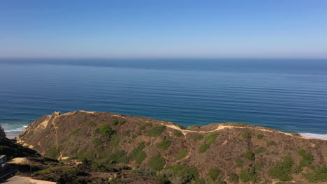 Panoramic-View-Above-Torrey-Pines-And-Luxurious-La-Jolla-Real-Estate-With-Revealing-Shot-Of-Scripps-Pier-In-Distance---panning-drone