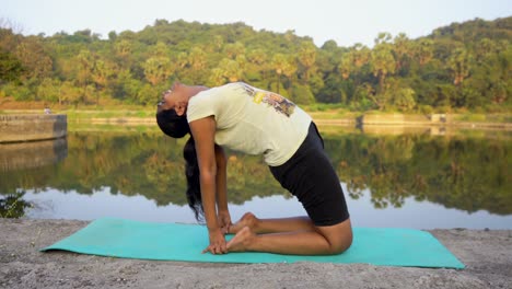 Indian-girl-doing-ustrasan-yoga-India-Mumbai-backbend-pose-yogsana-lake-side