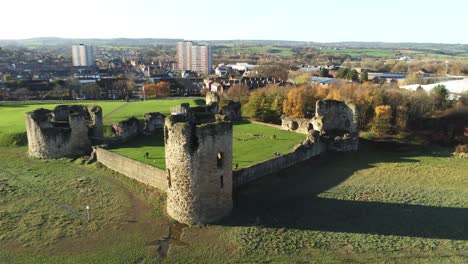 Ancient-Flint-castle-medieval-heritage-military-Welsh-ruins-aerial-view-landmark-slow-rise-tilt-down-left