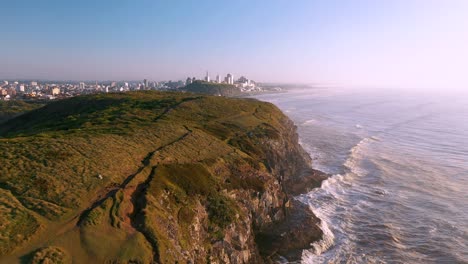 Aerial-cinematic-shot-of-high-rocky-cliffs-by-atlantic-ocean,-Torres,-Rio-Grande-do-Sul,-Brazil