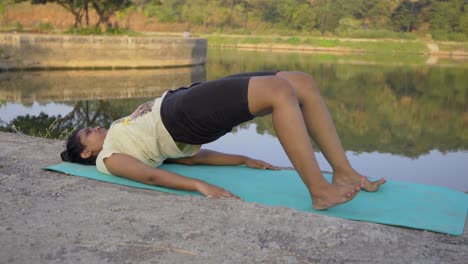 Amateur-Mädchen-Macht-Yoga-Pose-Brückenpose-Setu-Bandha-Sarvangasana-Am-Seeufer