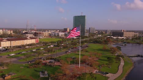 American-flag-and-Veterans-Memorial-park-in-Lake-Charles-with-the-damaged-Capital-One-building-in-Louisiana-post-Hurricane-Laura