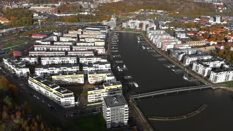 Aerial-view-of-Hisingen-in-Sweeden,-establishing-shot-of-a-City-in-a-gulf-with-docks-and-tall-apartment-buildings,-tilt-down