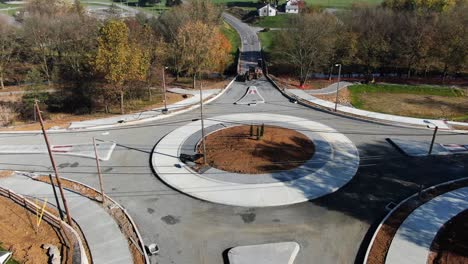 Rising-aerial-tilt-reveals-traffic-circle-roundabout-under-construction,-closed-to-cars-and-trucks
