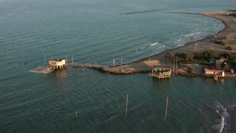 Luftaufnahme-Der-Täler-Bei-Ravenna,-Wo-Der-Fluss-Ins-Meer-Mündet,-Mit-Den-Typischen-Fischerhütten-Bei-Sonnenuntergang