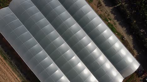 Spinning-aerial-view-looking-down-on-a-farmer's-greenhouse