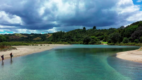 People-Stand-At-Coast-Of-Shallow-River-In-New-Zealand