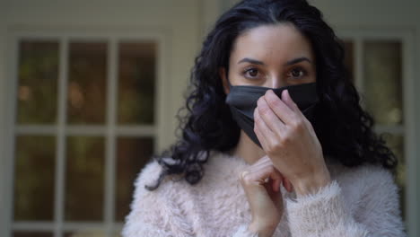 Young-Latina-woman-makes-sure-her-face-mask-fit-properly-over-her-nose---isolated