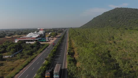 Flying-over-highway-in-India-as-cars-and-busses-pass-by-bellow