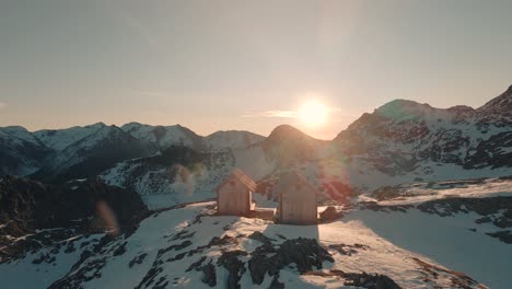 Drone-flying-over-two-cabins-at-sunrise