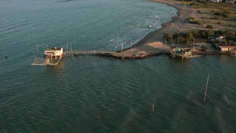 Luftaufnahme-Der-Täler-Bei-Ravenna,-Wo-Der-Fluss-Ins-Meer-Mündet,-Mit-Den-Typischen-Fischerhütten-Bei-Sonnenuntergang