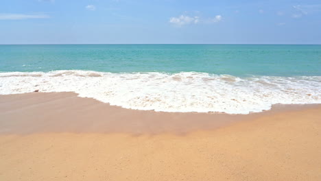 Zeitlupe-Einer-Großen-Welle,-Die-Sich-über-Den-Goldenen-Sand-Eines-Einsamen-Strandes-Ausbreitet