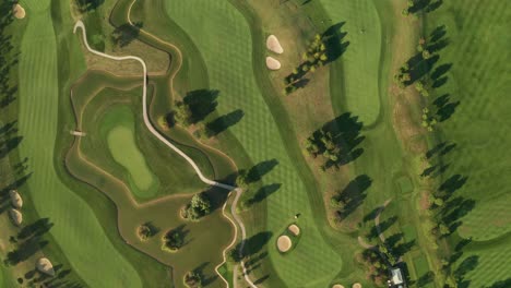 Aerial-view-of-a-golf-course-with-beautiful-abstract-patterns,-sand-pits,-trees-and-lakes