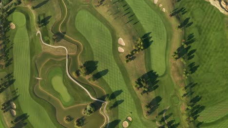 Aerial-view-of-a-golf-course-with-beautiful-abstract-patterns,-sand-traps,-trees-and-lakes