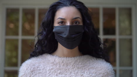 Young-attractive-Latina-woman-puts-on-a-face-mask-to-protect-herself-and-others-from-infection
