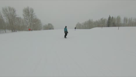 POV-Aufnahme-Von-Menschen,-Die-In-Zeitlupe-Auf-Einem-Snowboard-Fahren