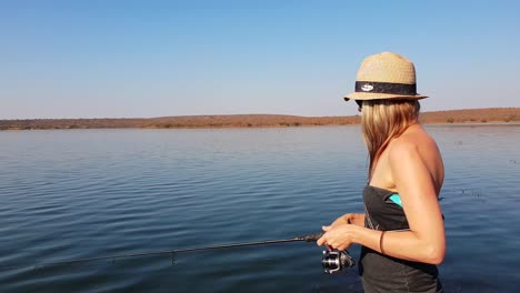 Hermosa-Chica-Pescando-Lubina-Desde-Un-Bote-En-Un-Día-Soleado-En-África
