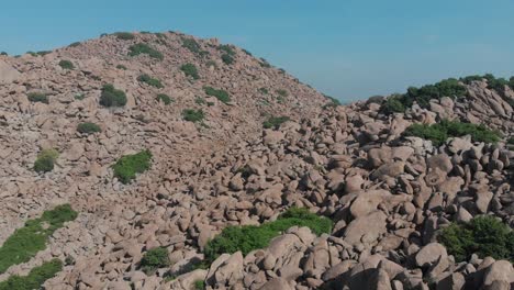Tiefflug-über-Felsen,-Die-Einen-Hügel-Mit-Grünen-Büschen-In-Einem-Ländlichen-Teil-Indiens-Bedecken