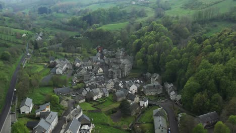 Misty-green-French-valley-and-hamlet-with-breathtaking-views,-aerial