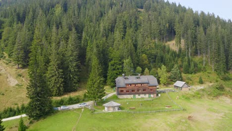 A-drone-shot-of-a-wooden-house-in-the-countryside-beside-the-forest