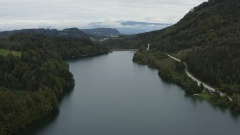 Freibach-reservoir-at-the-south-Austrian-Alps-on-cloudy-grey-day,-Aerial-flyover-rising-shot