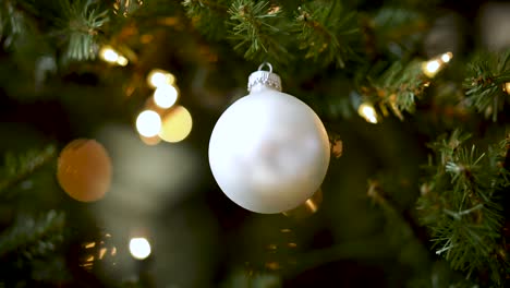 Beautiful-bauble-decoration-hanging-on-Christmas-tree,-festive-winter-scene