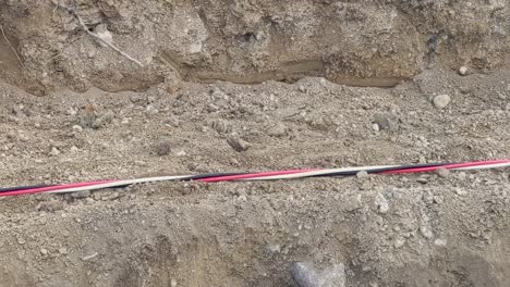 Large-three-strand-power-cable-being-dragged-across-a-construction-site