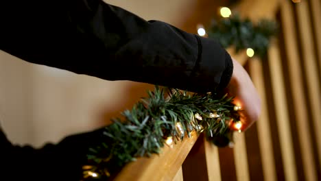 Mädchen-Schmücken-Die-Holzgeländer-Mit-Weihnachtsgirlanden-Und-Lichtern