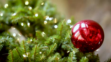Mujer-Joven-Colgando-Adorno-Rojo-Decorativo-En-El-árbol-De-Navidad,-Primer-Plano