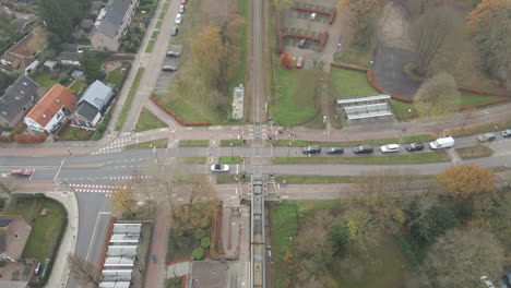 High-angle-view-of-train-leaving-station-and-driving-over-rail-road-crossing