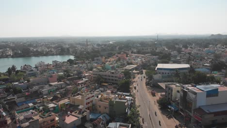 Aerial-flight-along-main-road-in-Tiruvannamalai-City-and-natural-pond-in-the-middle-of-town