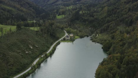 South-edge-of-Freibach-reservoir-dam-in-Austria-with-the-Stauseewirt-Greek-restaurant-left,-Aerial-dolly-out-reveal-shot