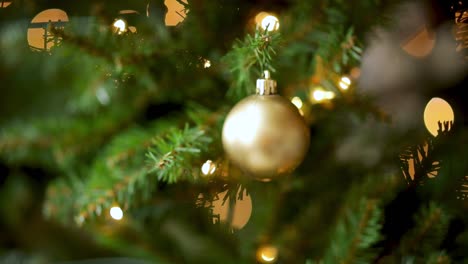 Goldene-Weihnachtskugel-Und-Lichter,-Die-An-Einem-Weihnachtsbaum-Hängen