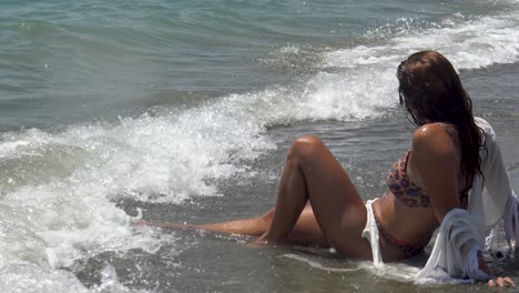 Side-view-of-a-neautiful-woman-enjoying-the-waves-at-the-beach-while-on-vacation