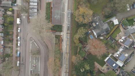 Top-down-aerial-of-people-boarding-train-at-small-train-station